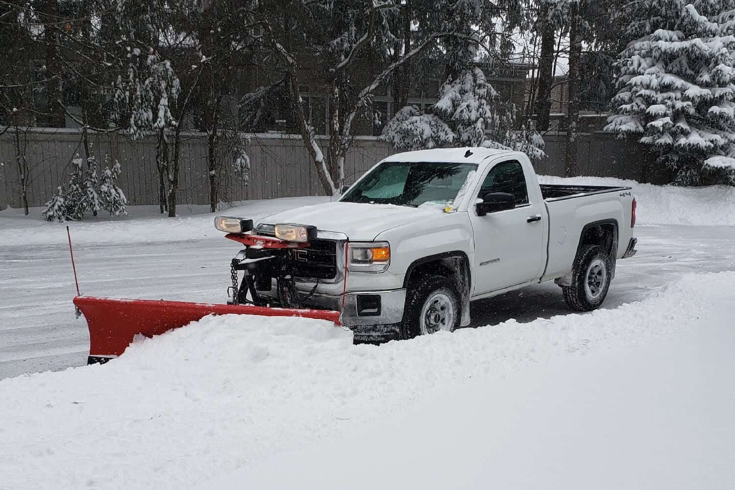 Snow plow clearing a commercial property in London Ontario